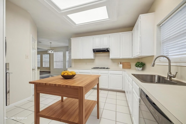 kitchen featuring white cabinets, hanging light fixtures, light countertops, under cabinet range hood, and a sink