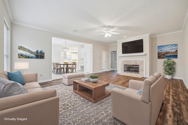 living room with a fireplace, wood finished floors, and crown molding