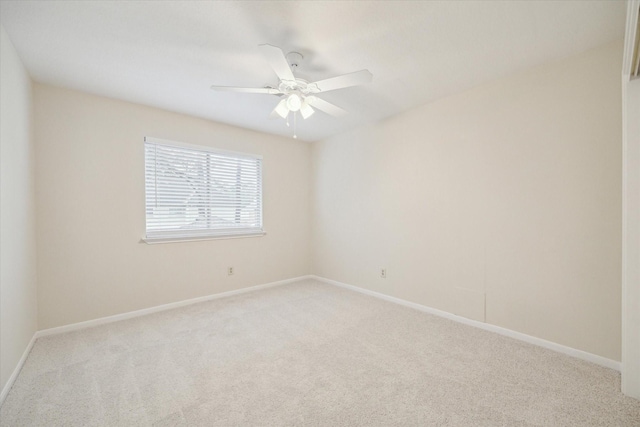 spare room with light carpet, ceiling fan, and baseboards