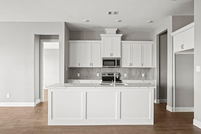 kitchen with stainless steel appliances, visible vents, a sink, and tasteful backsplash