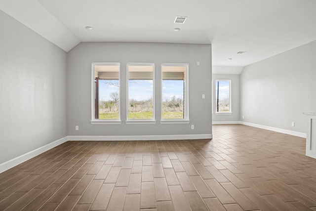 empty room featuring wood finish floors, visible vents, and baseboards