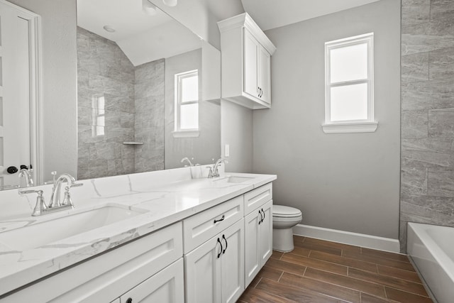 full bathroom featuring wood tiled floor, tiled shower, a sink, and baseboards