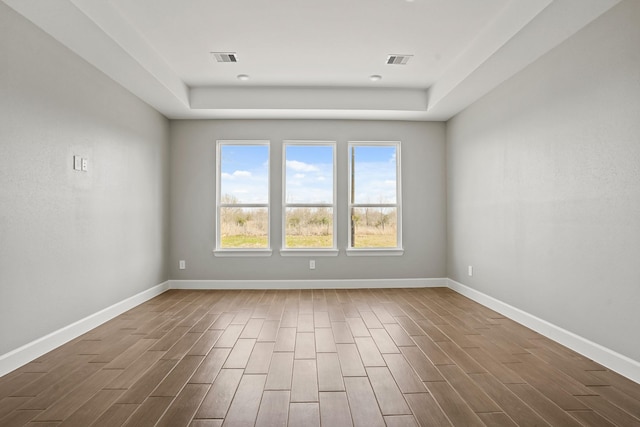 spare room featuring baseboards, visible vents, and dark wood-style flooring