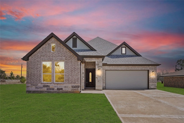 view of front of house with brick siding, a lawn, and an attached garage