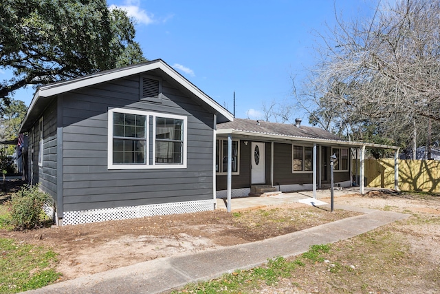 ranch-style home with covered porch and fence