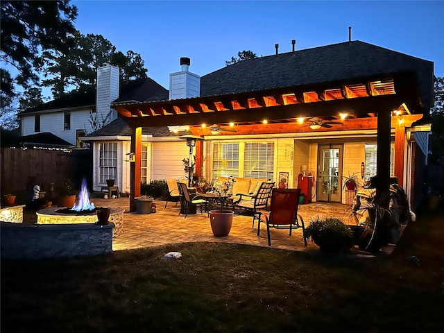 back of property with a patio, a chimney, a pergola, and an outdoor fire pit