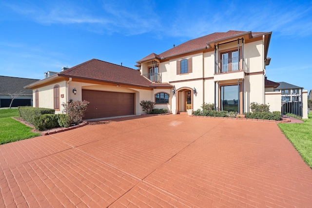 10804 Bourbon St, Willis, TX 77318 - mediterranean / spanish home featuring an attached garage, driveway, stucco siding, and a balcony