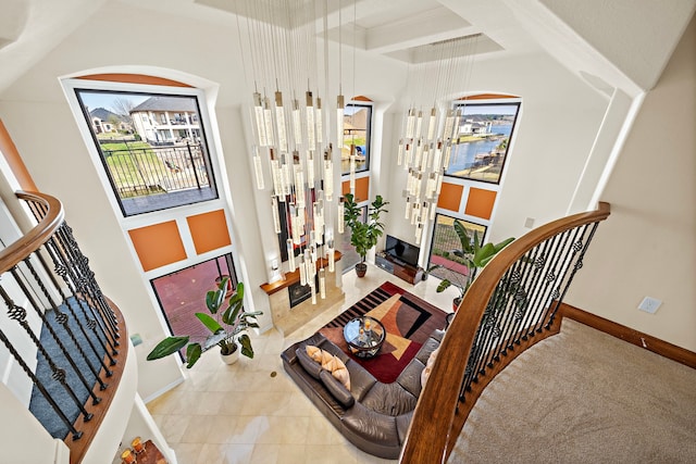 interior space featuring tile patterned flooring, coffered ceiling, beamed ceiling, and baseboards