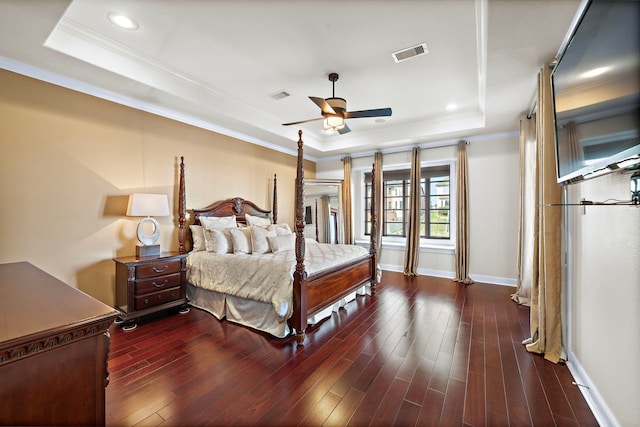 bedroom featuring wood finished floors, a raised ceiling, and visible vents