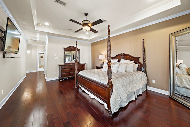 bedroom featuring dark wood-type flooring, a raised ceiling, visible vents, and baseboards