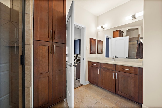 bathroom featuring tiled shower, vanity, and tile patterned floors