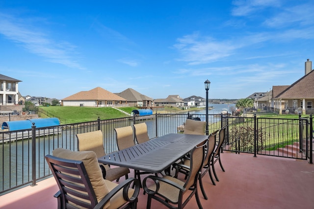 view of patio featuring a water view, a residential view, and outdoor dining area