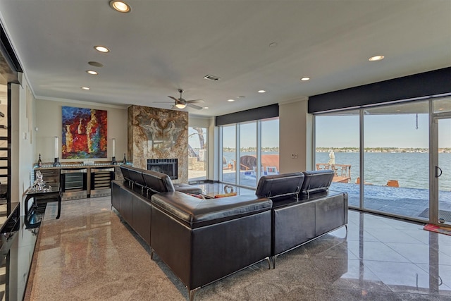 living area featuring wine cooler, a water view, granite finish floor, and recessed lighting