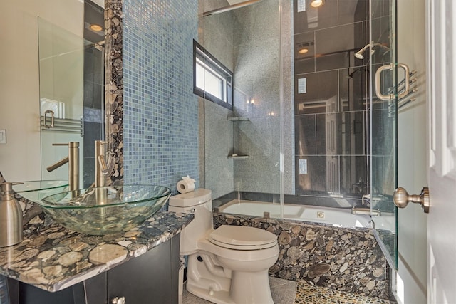 bathroom with tiled shower / bath, vanity, and toilet