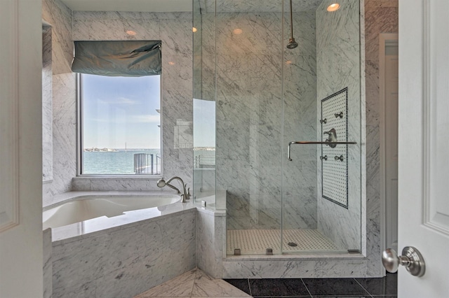 bathroom featuring a marble finish shower and a bath