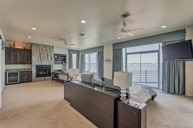 living area with light colored carpet, a large fireplace, visible vents, and wine cooler