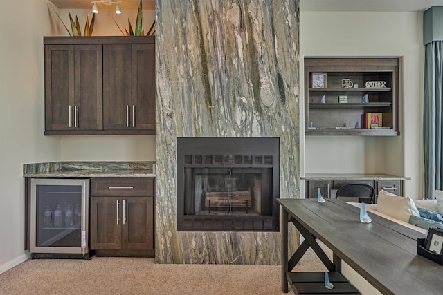 interior space with beverage cooler, a fireplace, and baseboards