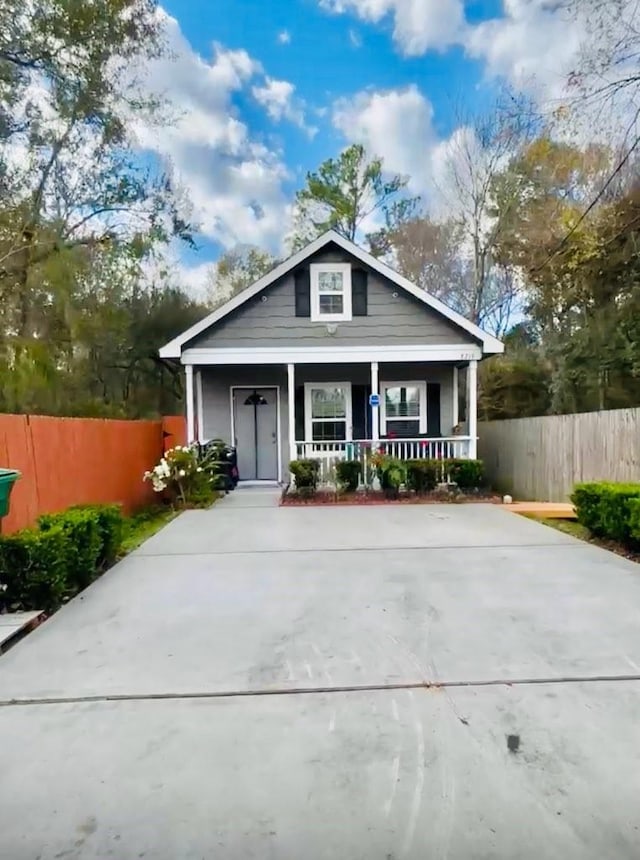 bungalow-style home with a porch and fence