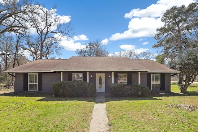 ranch-style home featuring a shingled roof, a front yard, and brick siding