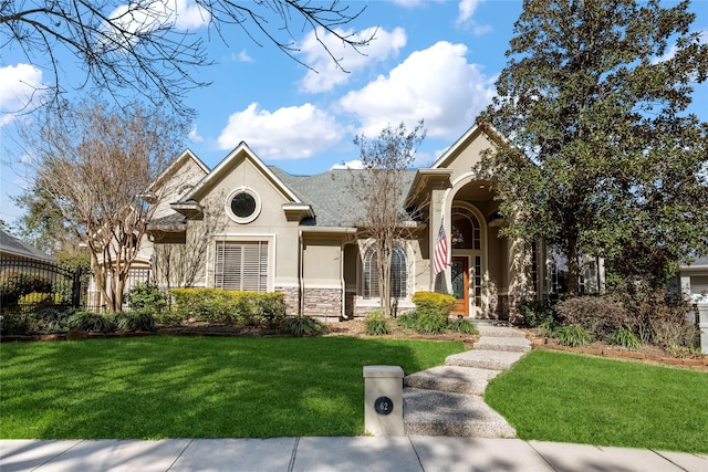 view of front of house featuring stone siding, a front yard, and stucco siding