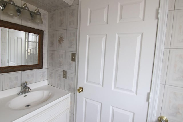 bathroom featuring decorative backsplash, tile walls, and vanity