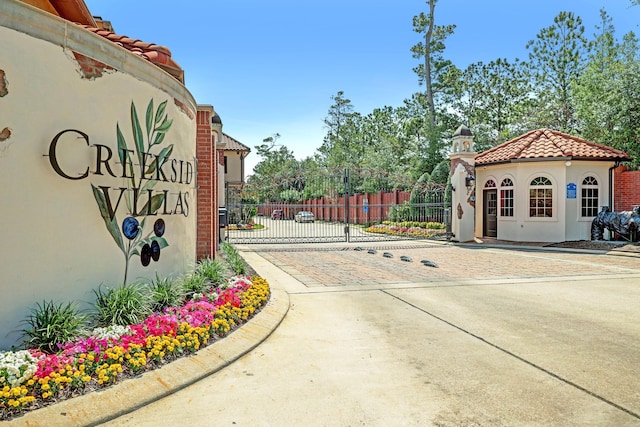 view of street featuring curbs, a gated entry, and a gate