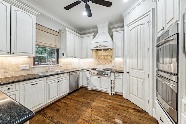 kitchen with white cabinetry, custom exhaust hood, and a sink