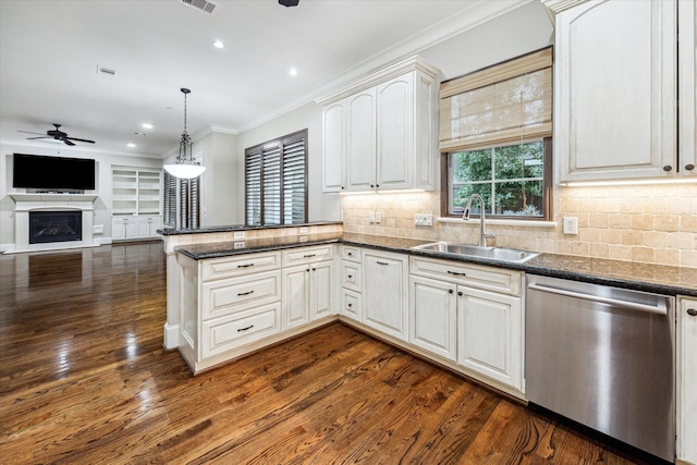 kitchen with hanging light fixtures, crown molding, stainless steel dishwasher, white cabinetry, and a sink