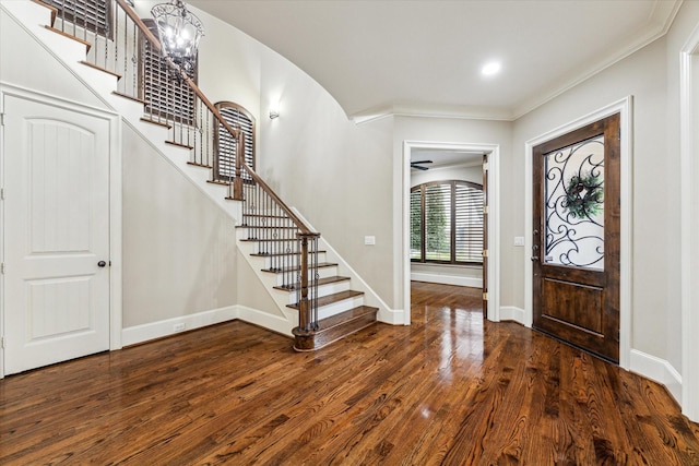 foyer entrance featuring baseboards, stairway, and dark wood finished floors