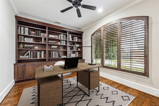 office area with visible vents, ornamental molding, dark wood-type flooring, a ceiling fan, and baseboards