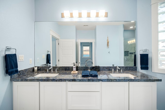 bathroom featuring double vanity, a shower stall, and a sink