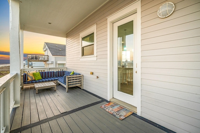 deck at dusk featuring an outdoor living space