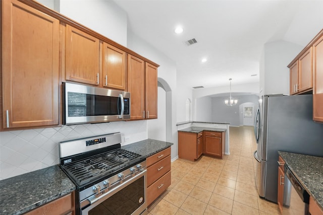 24510 Foxberry Glen Ln, Katy, TX 77494 - kitchen featuring dark stone countertops, visible vents, arched walkways, tasteful backsplash, and appliances with stainless steel finishes