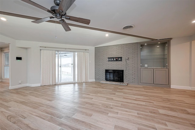 unfurnished living room featuring light wood finished floors, a fireplace, baseboards, and vaulted ceiling