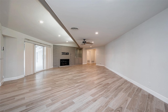 unfurnished living room with a fireplace, visible vents, light wood-style floors, ceiling fan, and baseboards