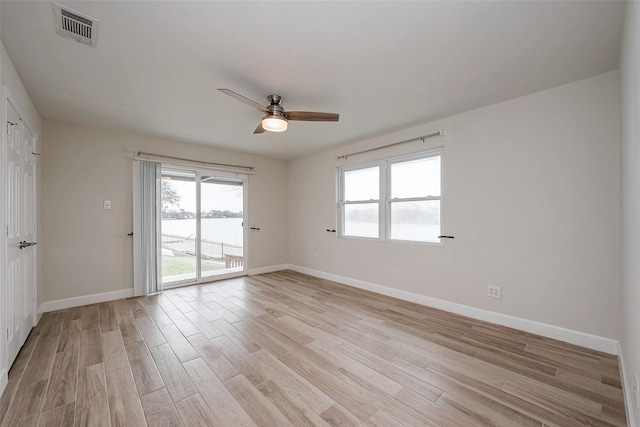 unfurnished room with light wood-type flooring, baseboards, and visible vents