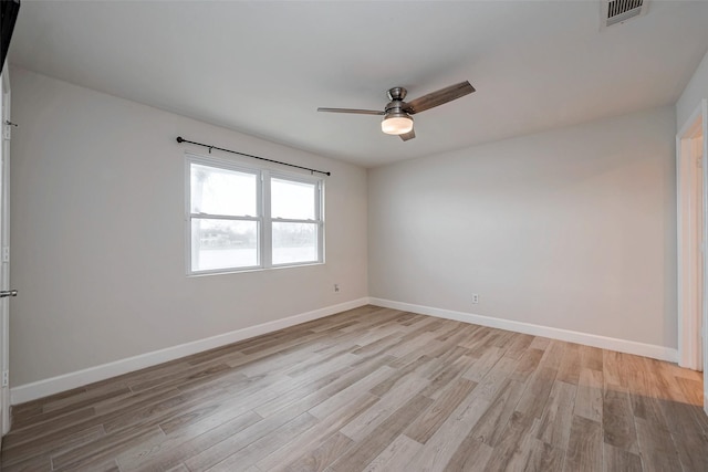 unfurnished room with light wood-style floors, visible vents, and baseboards