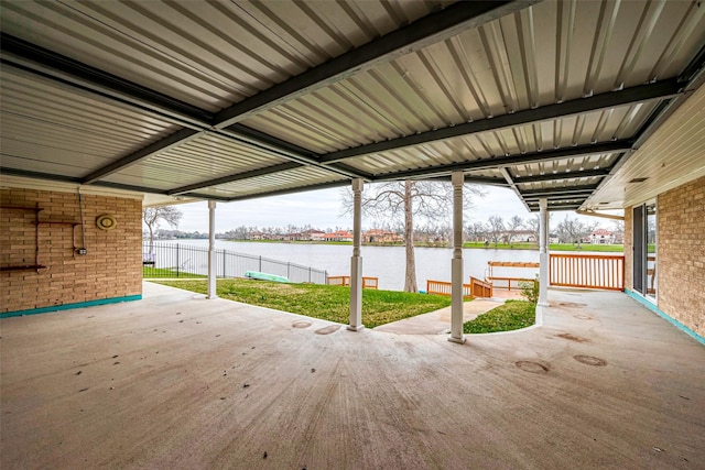 view of patio with a water view and fence