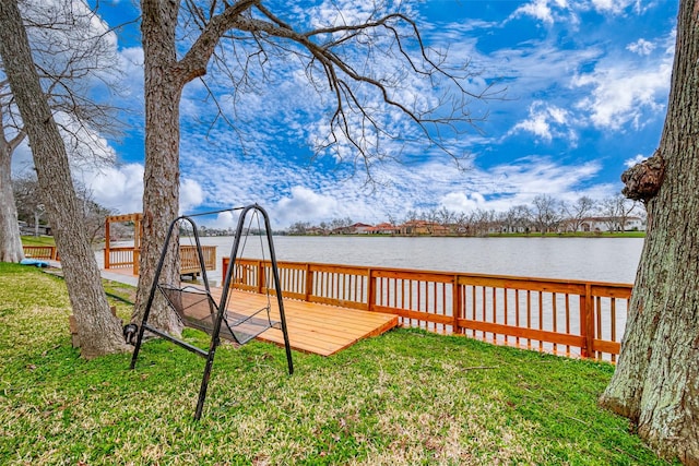 dock area featuring a lawn and a deck with water view