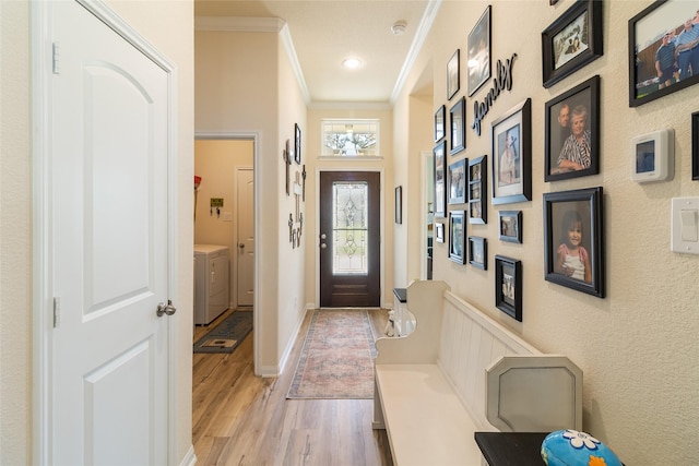 foyer featuring light wood-style flooring, baseboards, washer / dryer, and ornamental molding