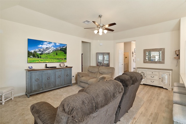 living room with visible vents, a ceiling fan, light wood-style floors, and baseboards