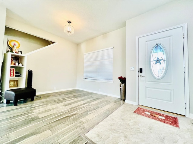 foyer featuring wood finished floors and baseboards