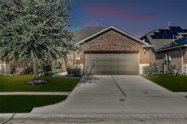 view of front of home featuring a garage, a front yard, concrete driveway, and brick siding