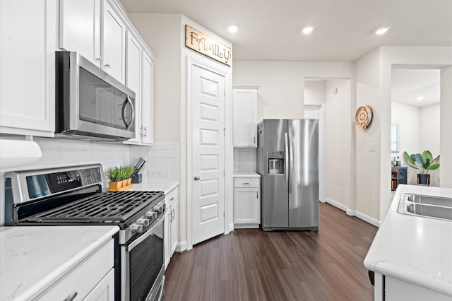 kitchen featuring recessed lighting, stainless steel appliances, dark wood-type flooring, white cabinets, and backsplash