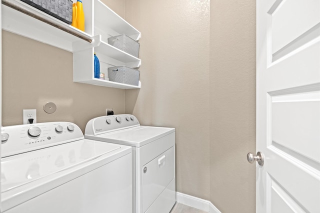 clothes washing area featuring laundry area, independent washer and dryer, and baseboards