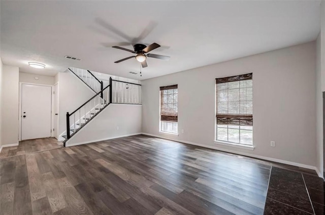 unfurnished living room with stairway, baseboards, visible vents, and dark wood finished floors