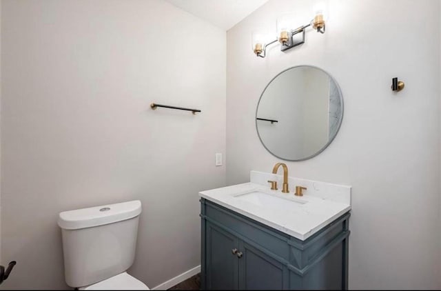 bathroom with toilet, vanity, and baseboards