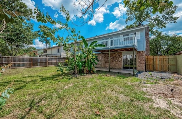 rear view of property featuring brick siding, a lawn, and a fenced backyard