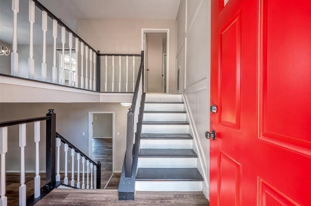 stairs featuring wood finished floors and baseboards