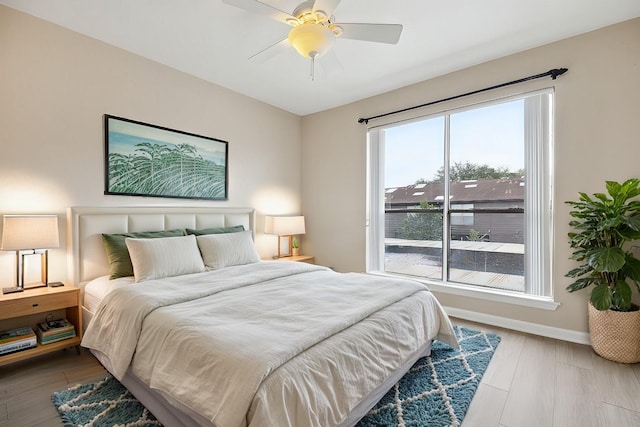 bedroom with a ceiling fan, baseboards, and wood finished floors